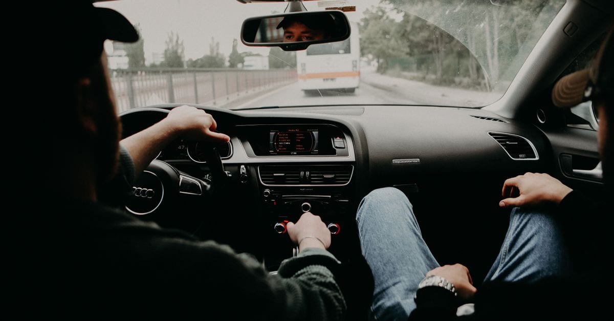 Student driving a manual car on a suburban road during a mock test session